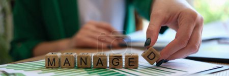 Close-up of woman collecting word managed with wooden cubes. Business development, planning and revenue growth