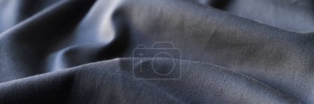 Foto de Top view of black wavy fabric textured background, cloth texture backdrop. Dark cloth for sewing. Beautiful crumpled pattern - Imagen libre de derechos