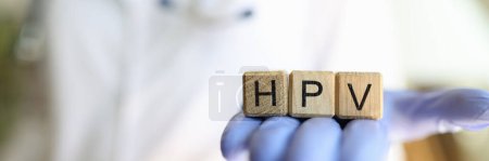 Close-up of female practitioner hand holding wooden cubes with word hpv. Medicine and human papillomavirus acronym concept