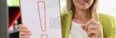 Photo for Portrait of smiling woman holding clipboard with red exclamation point. Interjection and exclamatory concept - Royalty Free Image