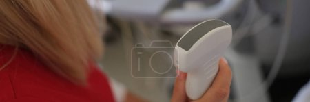 Téléchargez les photos : Female doctor holds ultrasound scanner device for examining patient in her hand. Ultrasound medical device for diagnostics close up. - en image libre de droit