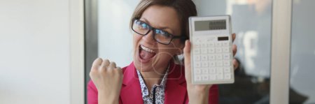 Photo for Excited business woman in the office showing 1000000 on a calculator, close-up. Profitable contract - Royalty Free Image