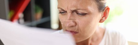 Photo for Portrait of focused woman trying read papers, squinting to see more clearly. Female having difficulties seeing text because of vision problems - Royalty Free Image