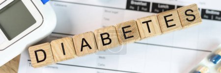 Photo for Word diabetes is assembled from wooden cubes with pills, glucometer and blood sugar tests on medical form paper. Concept of diabetes and blood sugar self-control. - Royalty Free Image