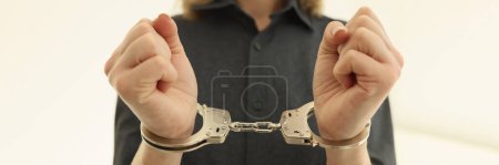 Photo for Woman with metal handcuffs in prison cell closeup. Arrest of criminal for judgement in state court. Inevitability of punishment for illegal actions - Royalty Free Image