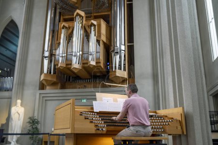 Foto de Islandia, Reikiavik - 2023: Organista profesional toca música en el órgano de la iglesia dentro de Hallgrimskirkja Reikiavik, Islandia. - Imagen libre de derechos