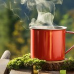 Red coffee mug on wooden table with nature landscape in the background