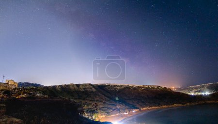 Foto de Milkyway apenas brilla sobre el acantilado de Malta. La contaminación lumínica hace difícil ver el cielo nocturno - Imagen libre de derechos