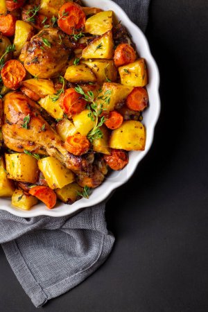 Foto de Baked chicken thighs and fried potatoes look delicious. - Imagen libre de derechos