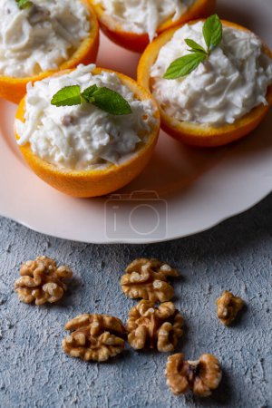 Photo for Celery salad with apple and walnuts served in orange cups. - Royalty Free Image