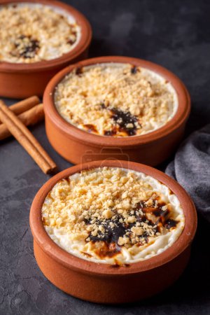 Photo for Baked rice pudding turkish milky dessert sutlac in earthenware casserole with hazelnuts - Royalty Free Image