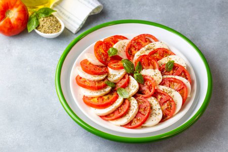 Photo for Italian caprese salad with sliced tomatoes, mozzarella, basil, olive oil - Royalty Free Image