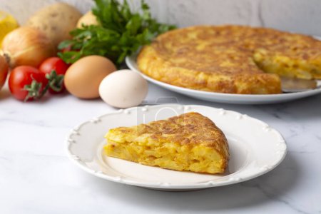 Téléchargez les photos : Spanish omelette with potatoes, typical spanish cuisine on gray concrete floor. Tortilla Espanola. Turkish name; Yumurtali patates - en image libre de droit