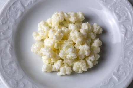 Photo for Kefir fermented milk drink with kefir grains. Homemade kefir stands in a glass, next to kefir grains and milk - Royalty Free Image