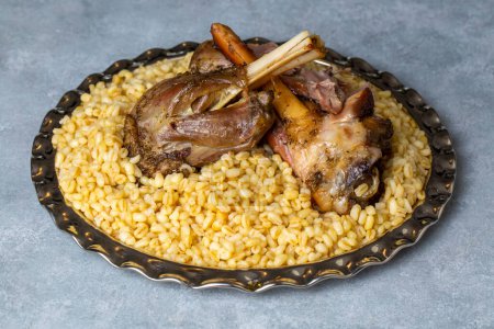 Téléchargez les photos : Turkish foods; lamb shank tandoori on bulgur wheat rice (Turkish name; bulgur bugday pilavi kuzu incik tandir) - en image libre de droit