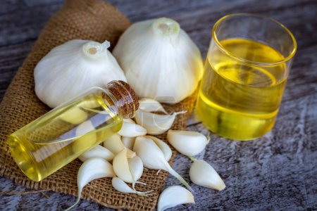 Photo for Fresh healthy garlic oil on the wooden background. - Royalty Free Image