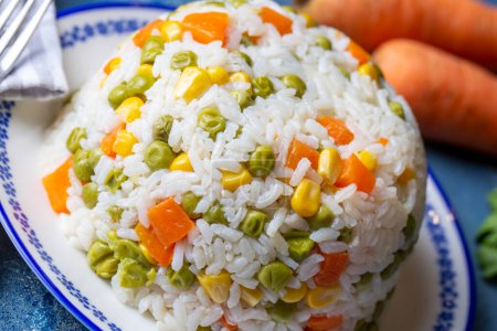 Téléchargez les photos : Délicieux pilaf de riz aux légumes avec pois verts, carottes et maïs doux (nom turc ; sebzeli pilav) - en image libre de droit