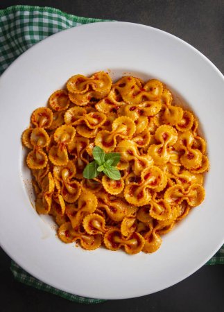 Photo for Farfalle pasta with tomato sauce, bow tie pasta tomatoes sauce (Turkish name; domatesli kelebek makarna) - Royalty Free Image