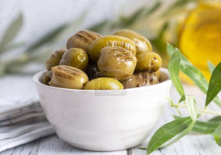 Photo for Grilled green olives. Tasty organic green olives in the plate. - Royalty Free Image