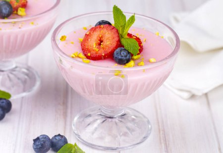 Téléchargez les photos : Dessert à la crème aux fraises avec quelques bleuets, pudding aux fraises - en image libre de droit