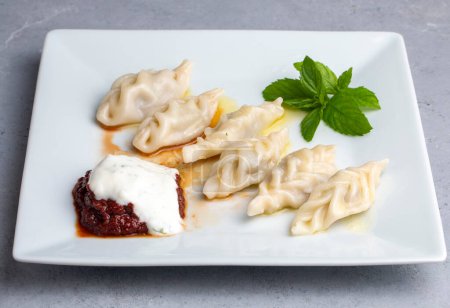 Téléchargez les photos : Nourriture traditionnelle manti sur assiette, vue sur le dessus. Le concept de cuisine orientale. Boulettes de manteau alimentaire ouzbek. (nom turc ; hinkel mantisi)) - en image libre de droit