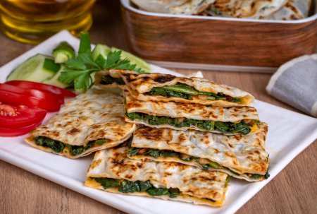 Photo for Traditional Turkish food, Turkish pancake gozleme with cheese and herb. The appetizer is Turkish pastry. There are varieties such as cheese, spinach, potato. - Royalty Free Image