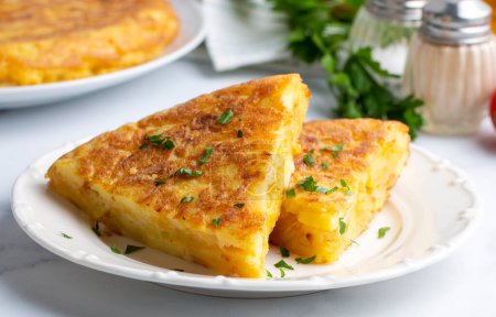 Photo for Spanish omelette with potatoes, typical spanish cuisine on gray concrete floor. Tortilla Espanola. Turkish name; Yumurtali patates - Royalty Free Image