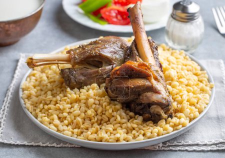 Téléchargez les photos : Turkish foods; lamb shank tandoori on bulgur wheat rice (Turkish name; bulgur bugday pilavi kuzu incik tandir) - en image libre de droit