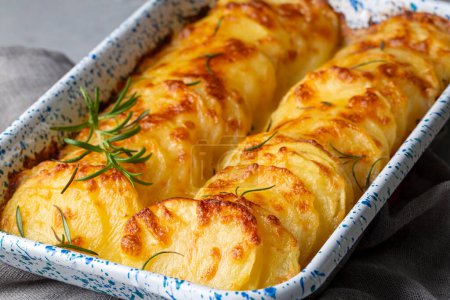 Foto de Rallado de patata - rallado (patatas al horno con crema y queso) con romero y tenedores (nombre turco; Patatas kremali) - Imagen libre de derechos