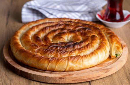 Photo for Turkish Tepsi Boregi, Round Borek, Tray pastry (Turkish name; rulo borek - ispanakli borek) - Royalty Free Image