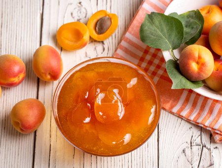 Photo for Apricot fruits and apricot jam on the wooden background - Royalty Free Image