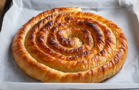 Photo for Turkish Tepsi Boregi, Round Borek, Tray pastry (Turkish name; rulo borek - ispanakli borek) - Royalty Free Image