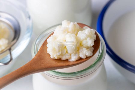 Photo for Kefir fermented milk drink with kefir grains. Homemade kefir stands in a glass, next to kefir grains and milk - Royalty Free Image