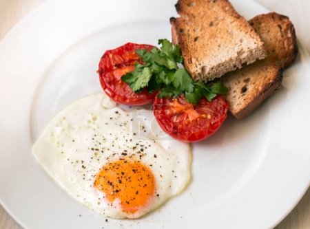 Téléchargez les photos : Tranches frites de délicieux œufs à côté d'une tranche de pain grillé
. - en image libre de droit