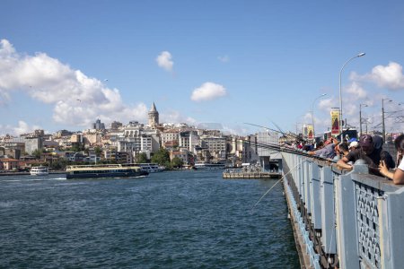Foto de Estambul - Turquía, 18 de junio de 2022, Pescador, Gente en el Puente de Galata y la Torre de Galata en la parte posterior - Imagen libre de derechos