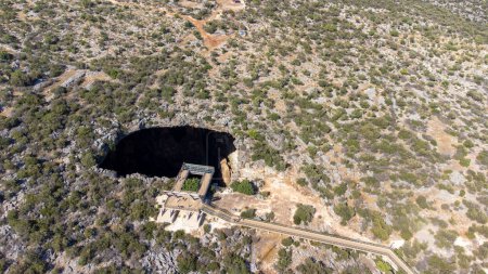 Photo for Heaven and hell (Cennet and Cehennem) are two large sinkholes, There is a chapel in paradise cave. Aerial view drone shooting, Mersin Province, Turkey - Royalty Free Image