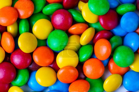 Foto de Una pila de botones de chocolate recubiertos de caramelo de color arco iris aislados - Imagen libre de derechos