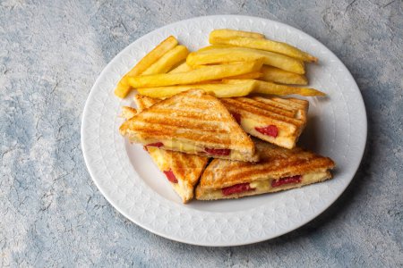 Photo for Turkish toast, mixed toast with cheddar cheese, sausage and ham, with fried potatoes (Turkish name; Karisik tost) - Royalty Free Image