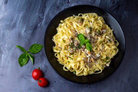 Téléchargez les photos : Homemade Italian fettuccine pasta (Fettuccine al Funghi Porcini) with mushroom and cream sauce. Traditional Italian cuisine. - en image libre de droit