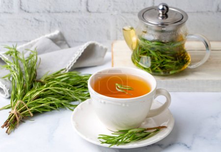 Photo for Cup of healthy rosemary tea with fresh rosemary bunch on rustic background, winter herbal hot drink concept, salvia rosmarinus - Royalty Free Image