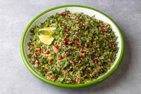 Photo for Tabbouleh salad is a traditional middle eastern or arab dish. Vegetarian salad with parsley, mint, bulgur, tomato. Turkish name; Tabule salatasi - Royalty Free Image