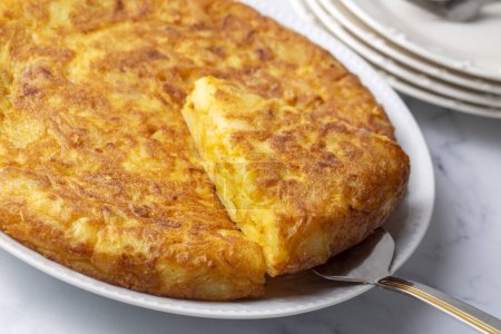 Photo for Spanish omelette with potatoes, typical spanish cuisine on gray concrete floor. Tortilla Espanola. Turkish name; Yumurtali patates - Royalty Free Image