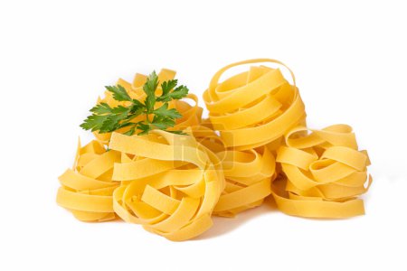 Homemade egg pasta tagliatelle. Raw nest noodles, uncooked ribbon fettuccine, dry long rolled macaroni isolated on white background top view