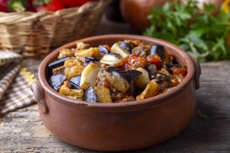 Téléchargez les photos : Vue du dessus du plat turc Guvech - viande cuite au four avec aubergine et traditionnellement servie en pot de faïence (nom turc ; etli patlican guvec) - en image libre de droit