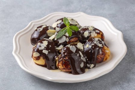 Photo for Delicious profiteroles with chocolate and white plate. - Royalty Free Image