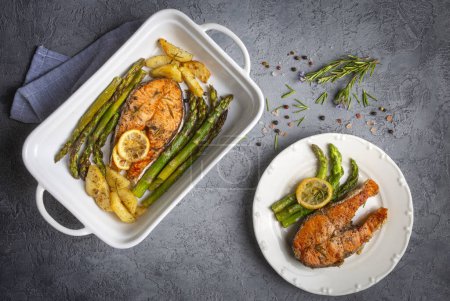 Photo for Grilled, baked salmon served on a plate with asparagus and potatoes. - Royalty Free Image