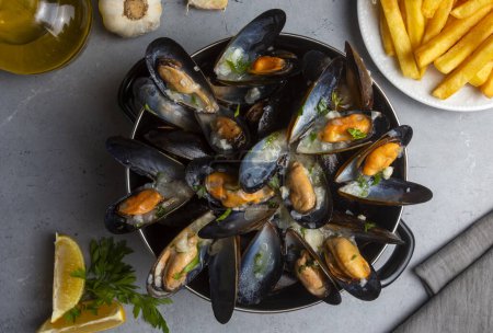 Téléchargez les photos : Delicious seafood mussels with parsley sauce and lemon. Delicious steamed mussels - en image libre de droit