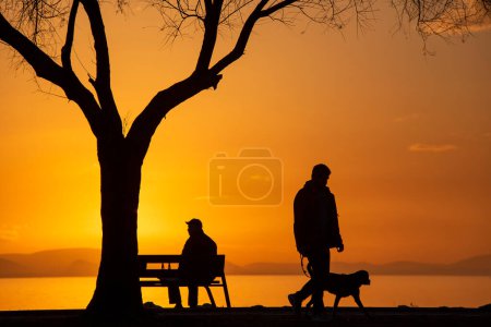 Téléchargez les photos : Bostanli / Izmir / Turquie, 12 février 2019, Les silhouettes des gens au coucher du soleil - en image libre de droit