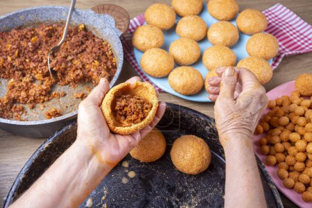 Photo for Traditional Turkish Food; Stuffed Meatballs, Turkish known as "icli kofte". Woman making Stuffed Meatballs at home. - Royalty Free Image
