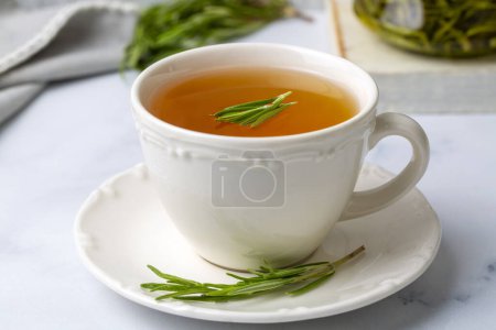 Téléchargez les photos : Tasse de thé au romarin sain avec bouquet de romarin frais sur fond rustique, concept de boisson chaude à base de plantes d'hiver, salvia rosmarinus - en image libre de droit